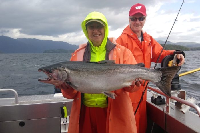 fisherman holds up King salmon (Chinook) caught sport fishing at a fishing lodge in Ketchikan Alaska