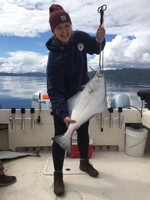 fisherman poses with halibut caught on a guided fishing charter in Ketchikan Alaska