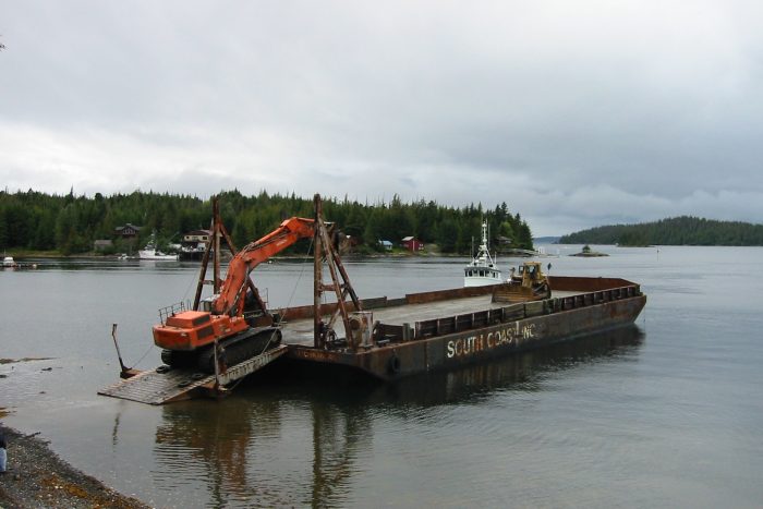 Tug and Equipment Barge for Lodge Construction Construction barge with backhoe and excavator used for development of Chinook Shores Lodge