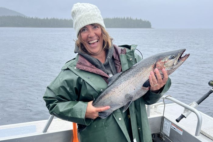 fisherman holds up King salmon (Chinook) caught sport fishing at a fishing lodge in Ketchikan Alaska