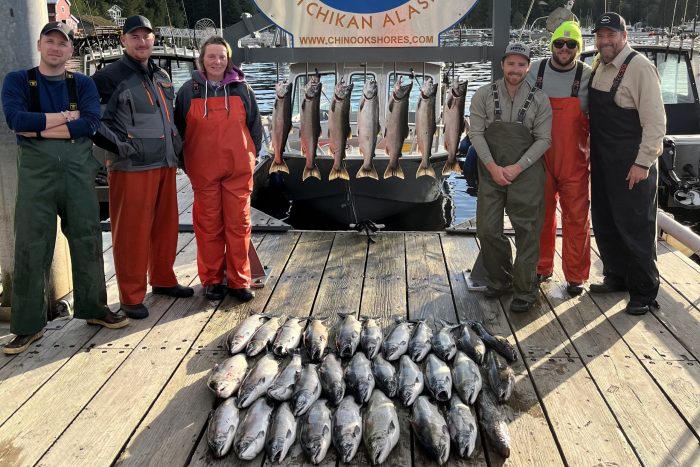 fishermen pose with limit of silver salmon (coho salmon) at fishing lodge in Ketchikan