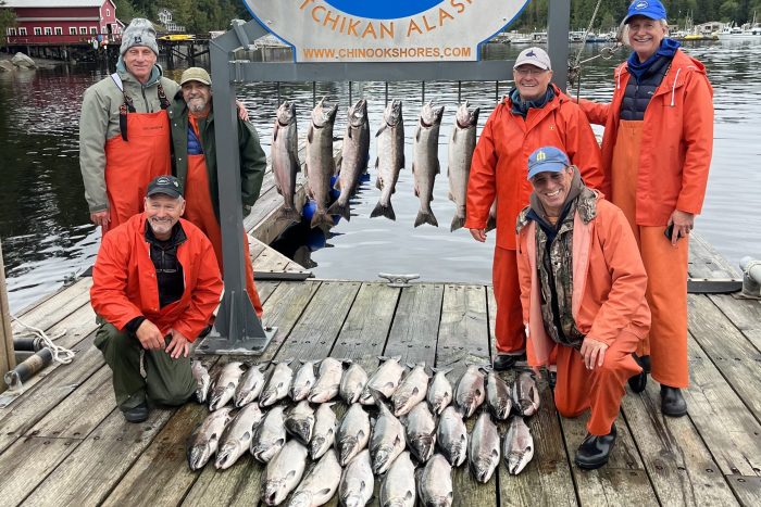 fishermen pose with limit of silver salmon (coho salmon) at fishing lodge in Ketchikan